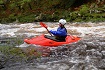 Paddling a river in the Riot Thunder white water kayak